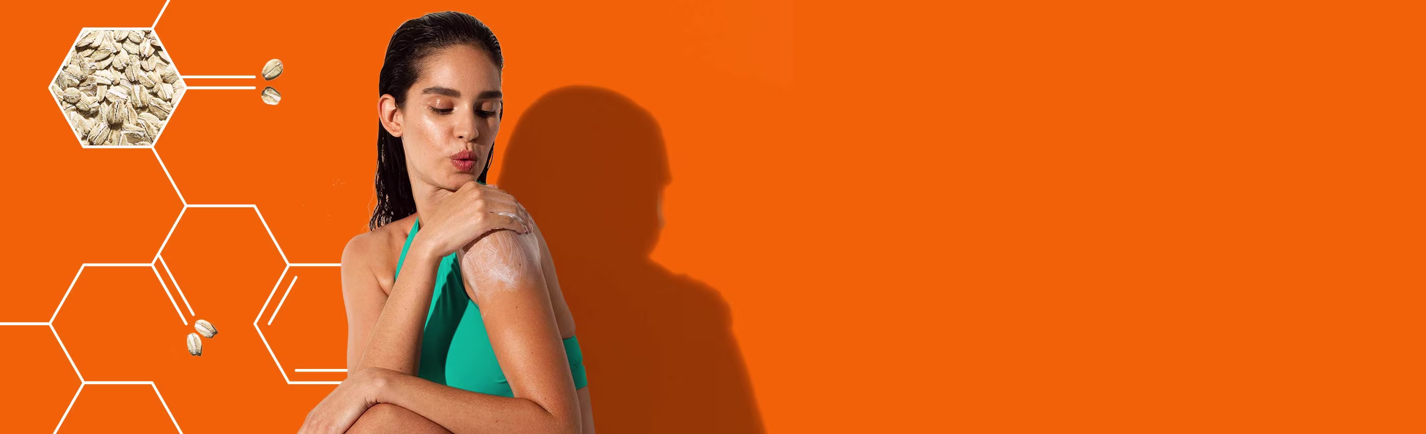 woman putting aveeno lotion on her shoulder against a bright orange background