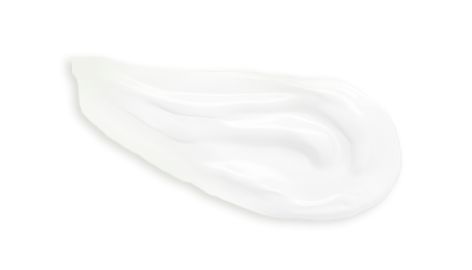 Shiny white cream on a white surface showcasing its thicker texture and uniform color