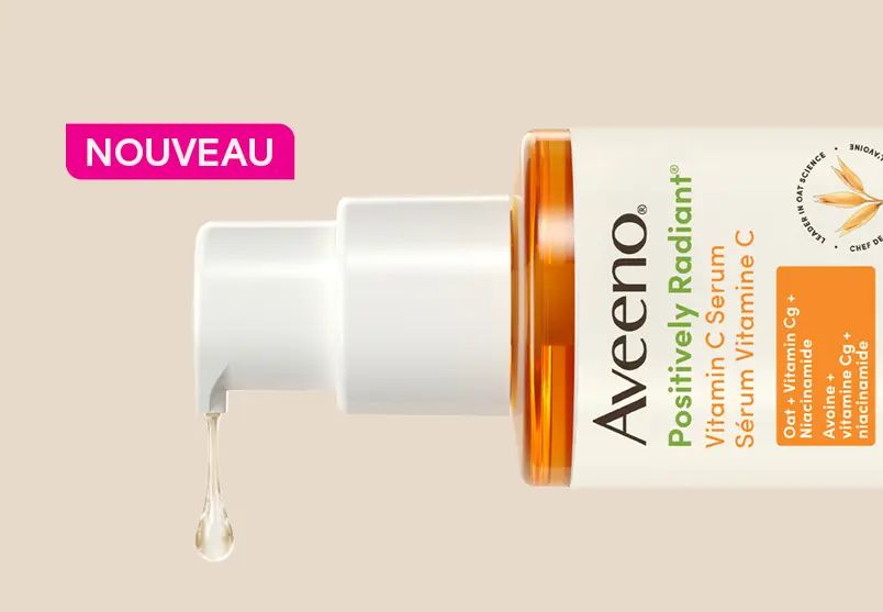 Femme souriante à côté d’un pot de la crème hydratante quotidienne Aveeno®