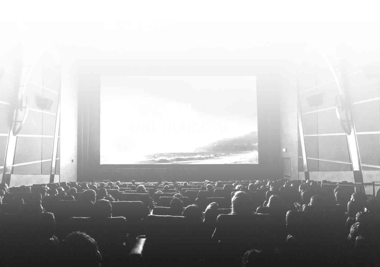 Auditorium full of people facing a movie screen