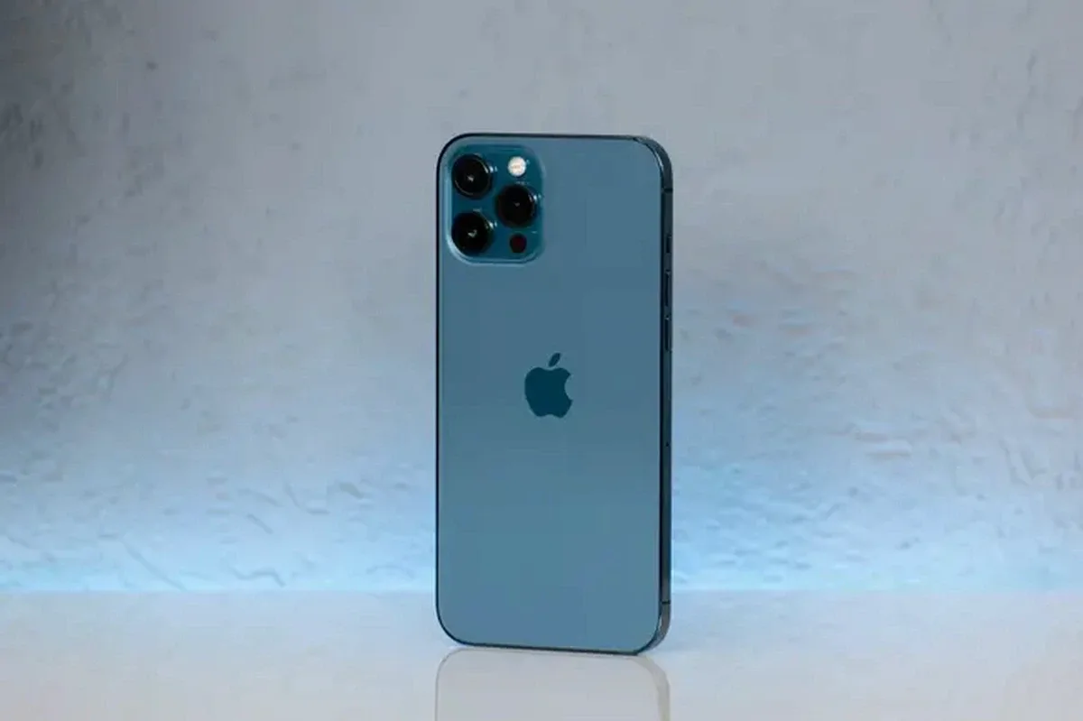 Blue iPhone standing on a white surface with a triple camera system