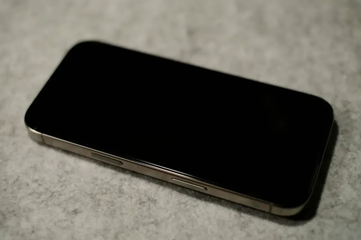 Smartphone with black screen on a gray surface
