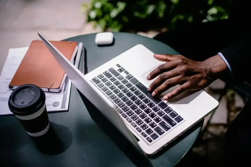 Person working on a laptop at an outdoor table