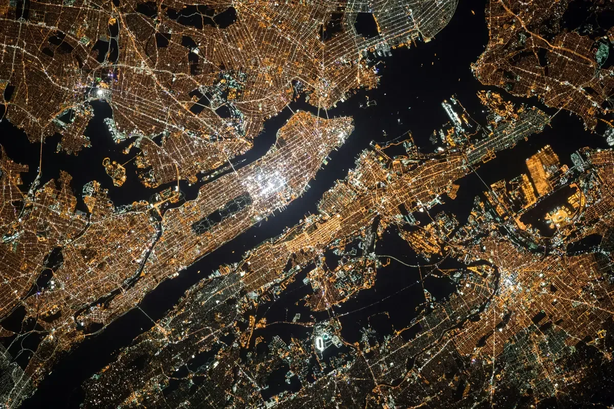 A night view of a city with bright lights and dark waterways