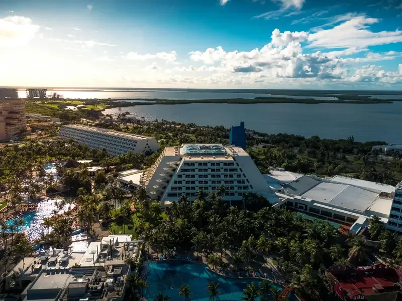 Aerial view of a beachfront resort in Cancun with pools and palm trees