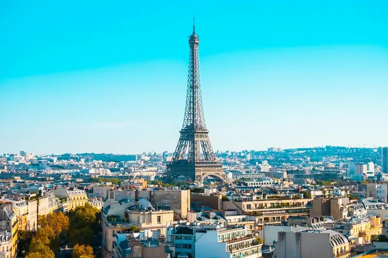 Eiffel Tower in Paris with a clear sky and cityscape in the background
