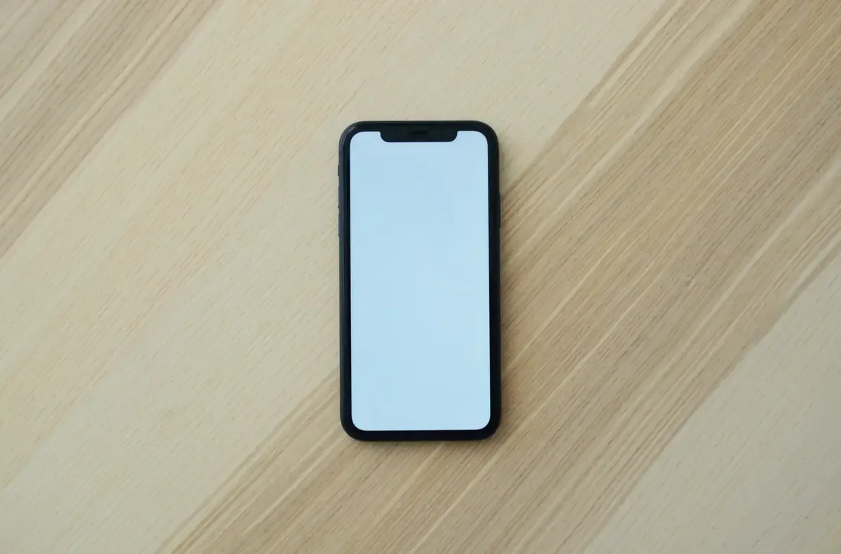 Smartphone with a blank screen on a wooden table