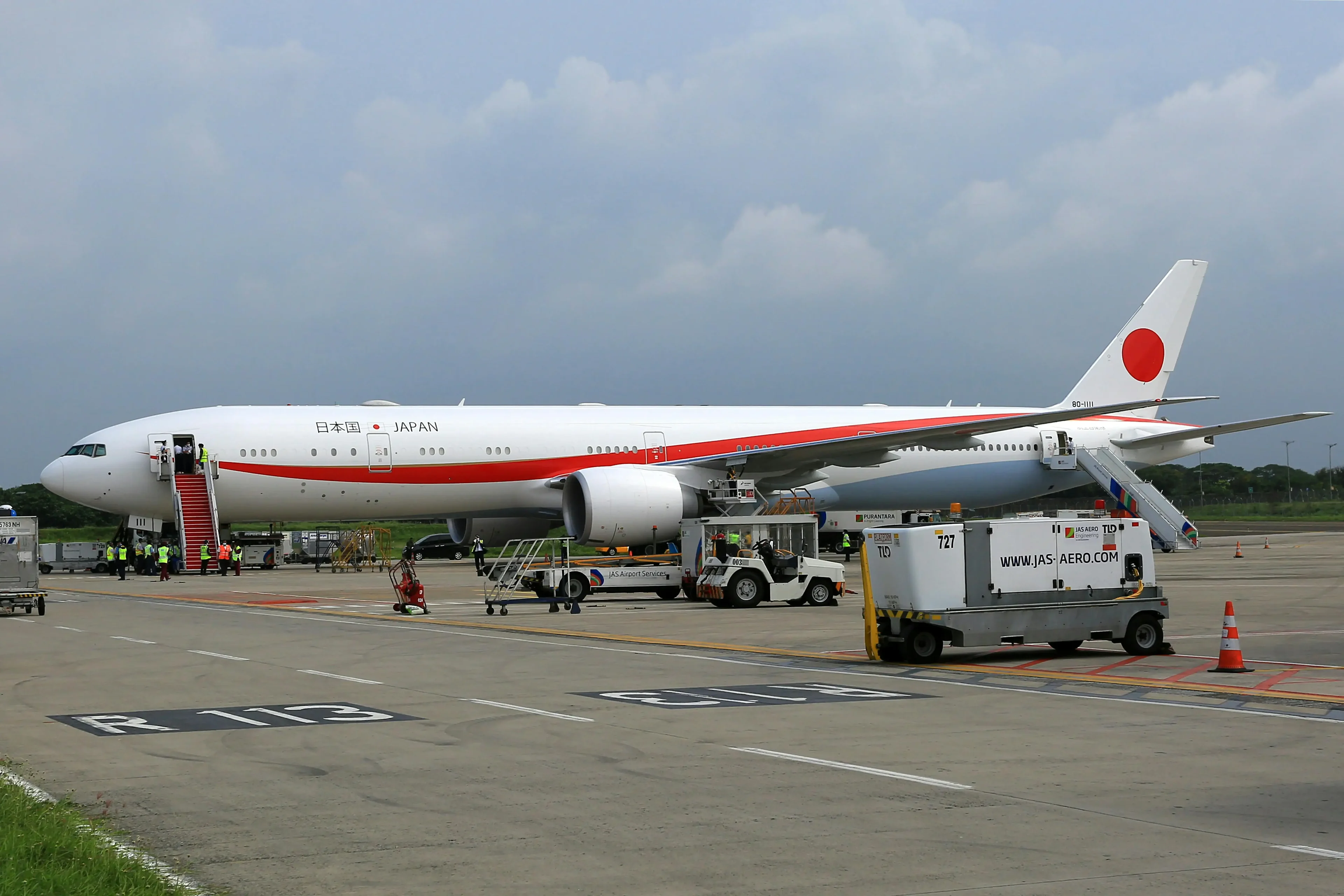 The red and white airplane on the airport runway.