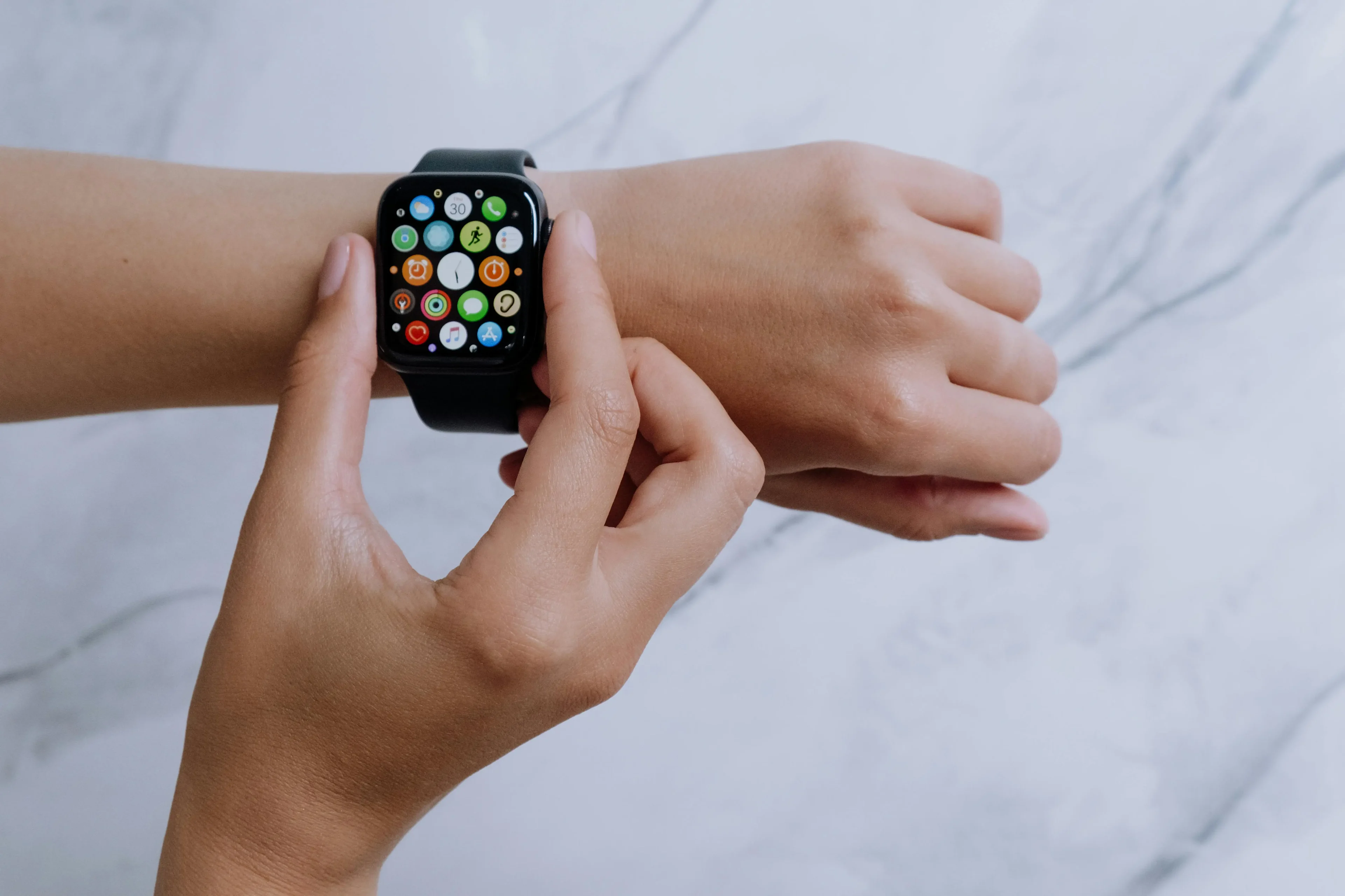 Person using a smartwatch with app icons on screen