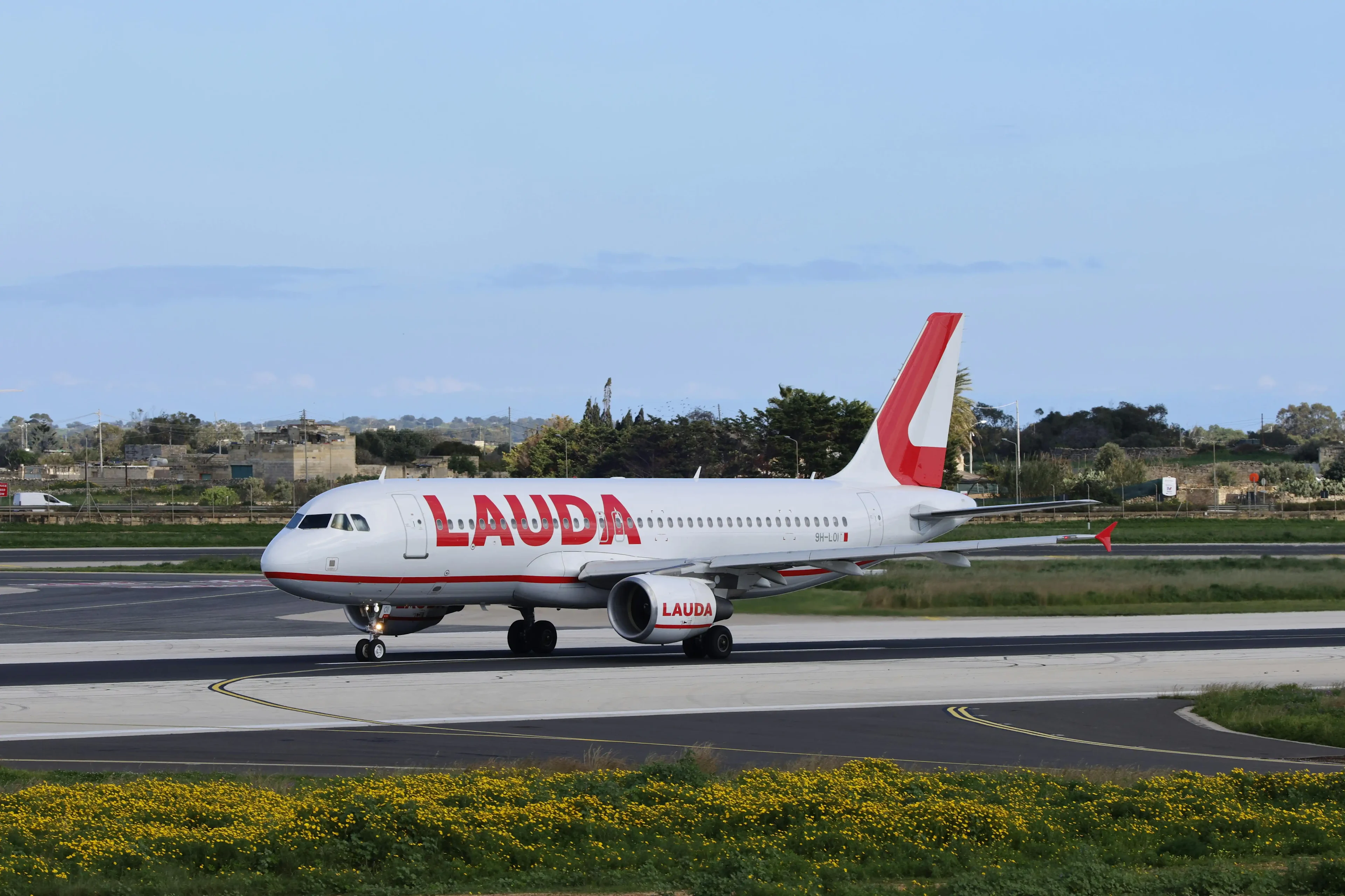 on the airport runway is a red and white airplane