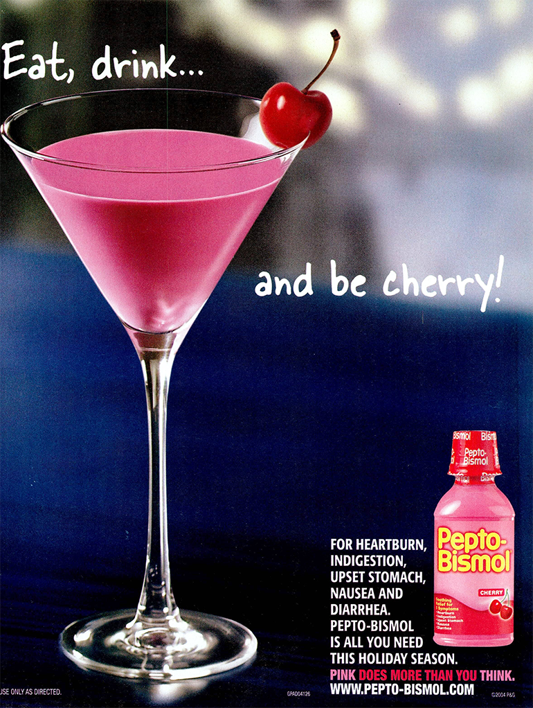 A glass full of pink liquid, a cherry on the rim and an old bottle of Pepto-Bismol Cherry flavor.