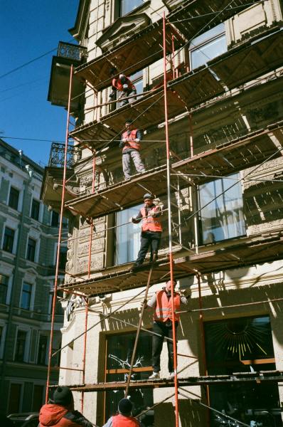 Des hommes équipés travaillant sur un chantier. Ils sont sur des échaffaudages