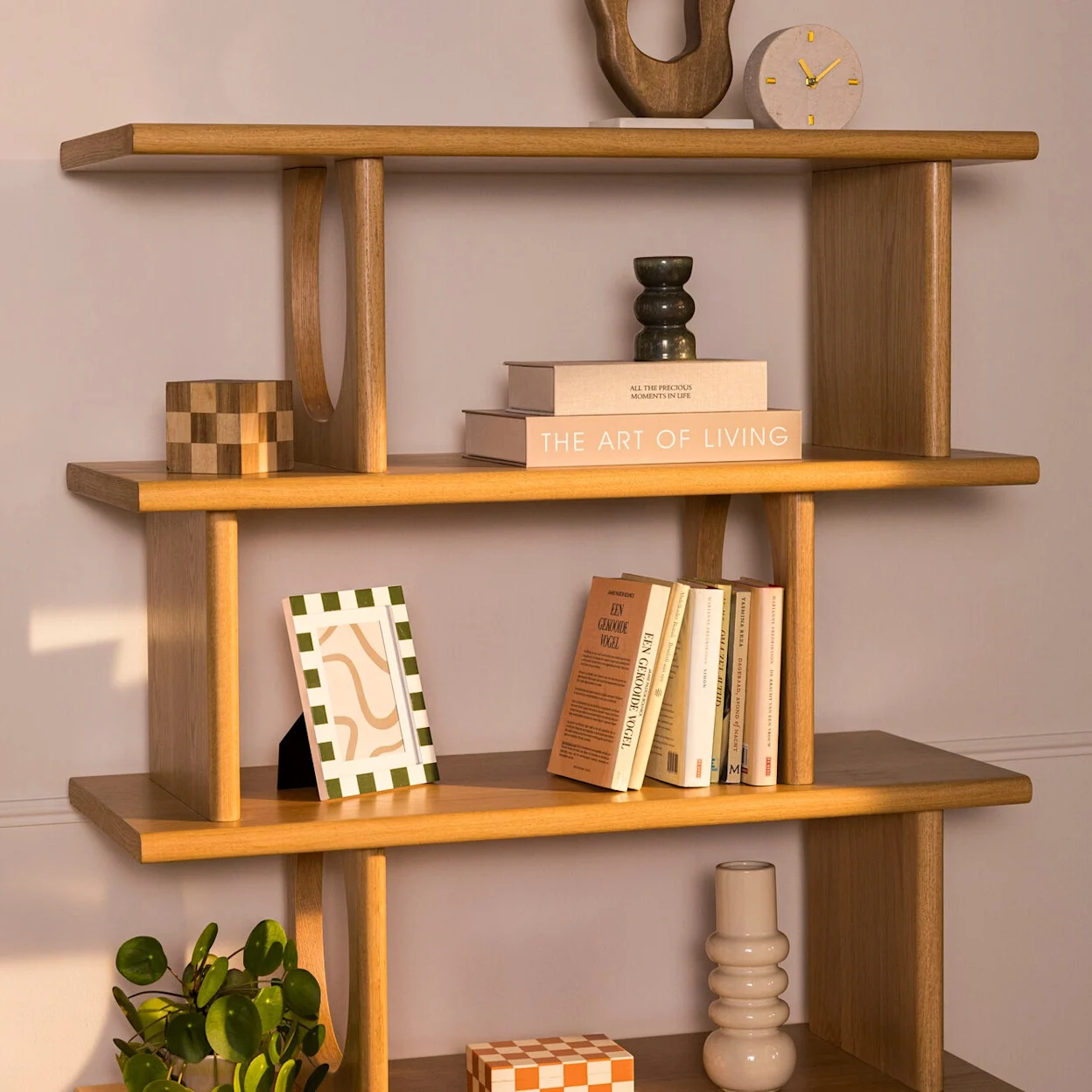 Close-up van houten wandrek met boeken en woonaccessoires.