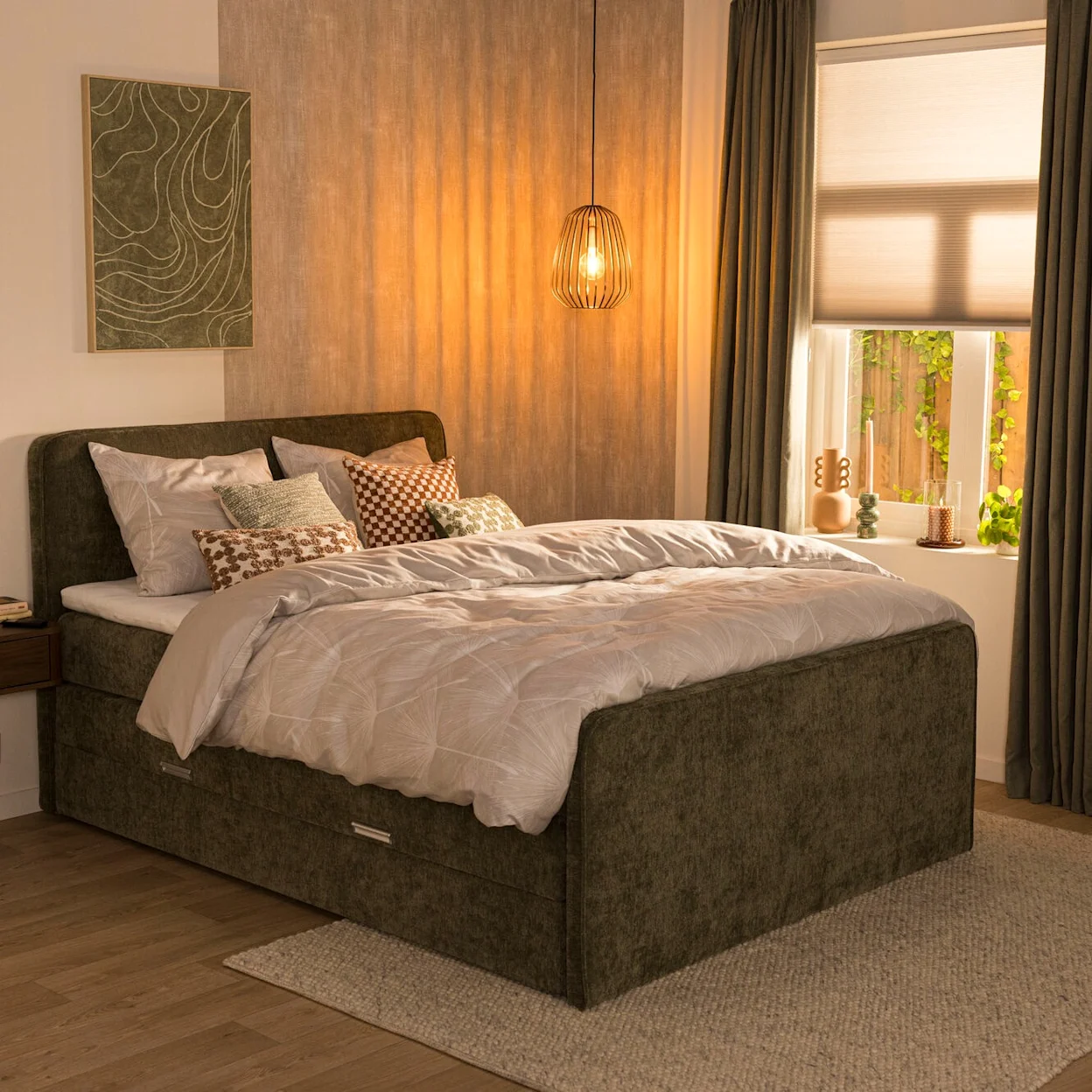 Vergrijsd groene boxspring Mori met afgerond hoofd- en voetbord in een warme slaapkamer