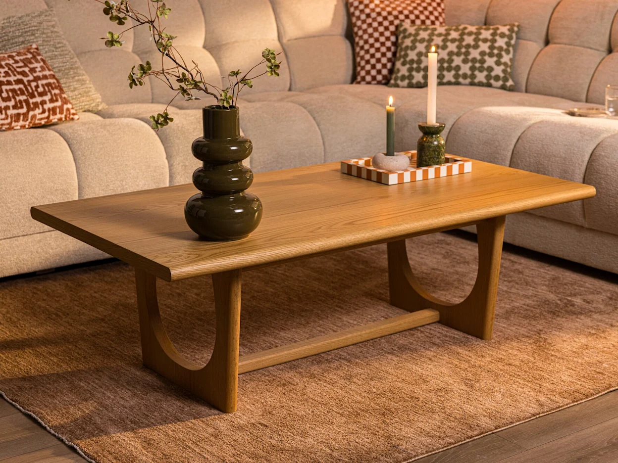 Houten salontafel met ronde vormen en decoratie in een warme woonkamer met een beige bank.