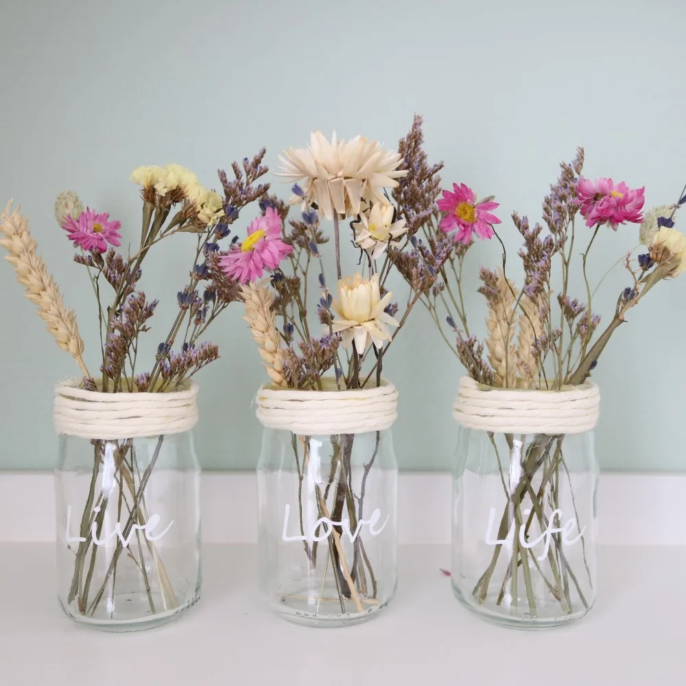 Glazen potjes met daarin droogbloemen