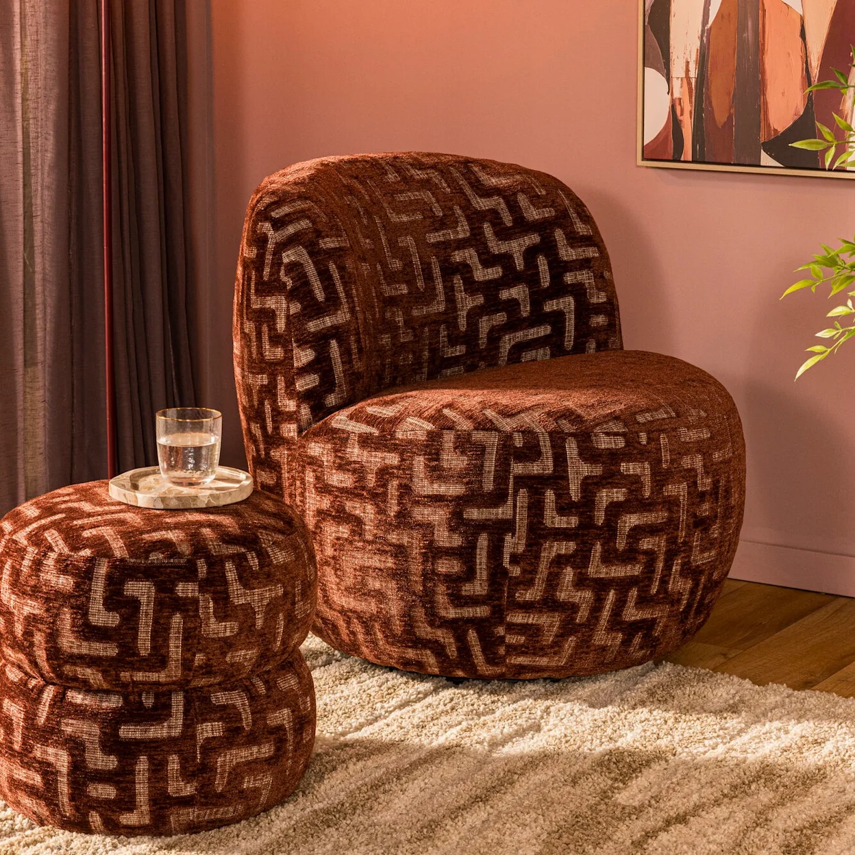 Fauteuil en poef met grafisch patroon in een warm interieur.