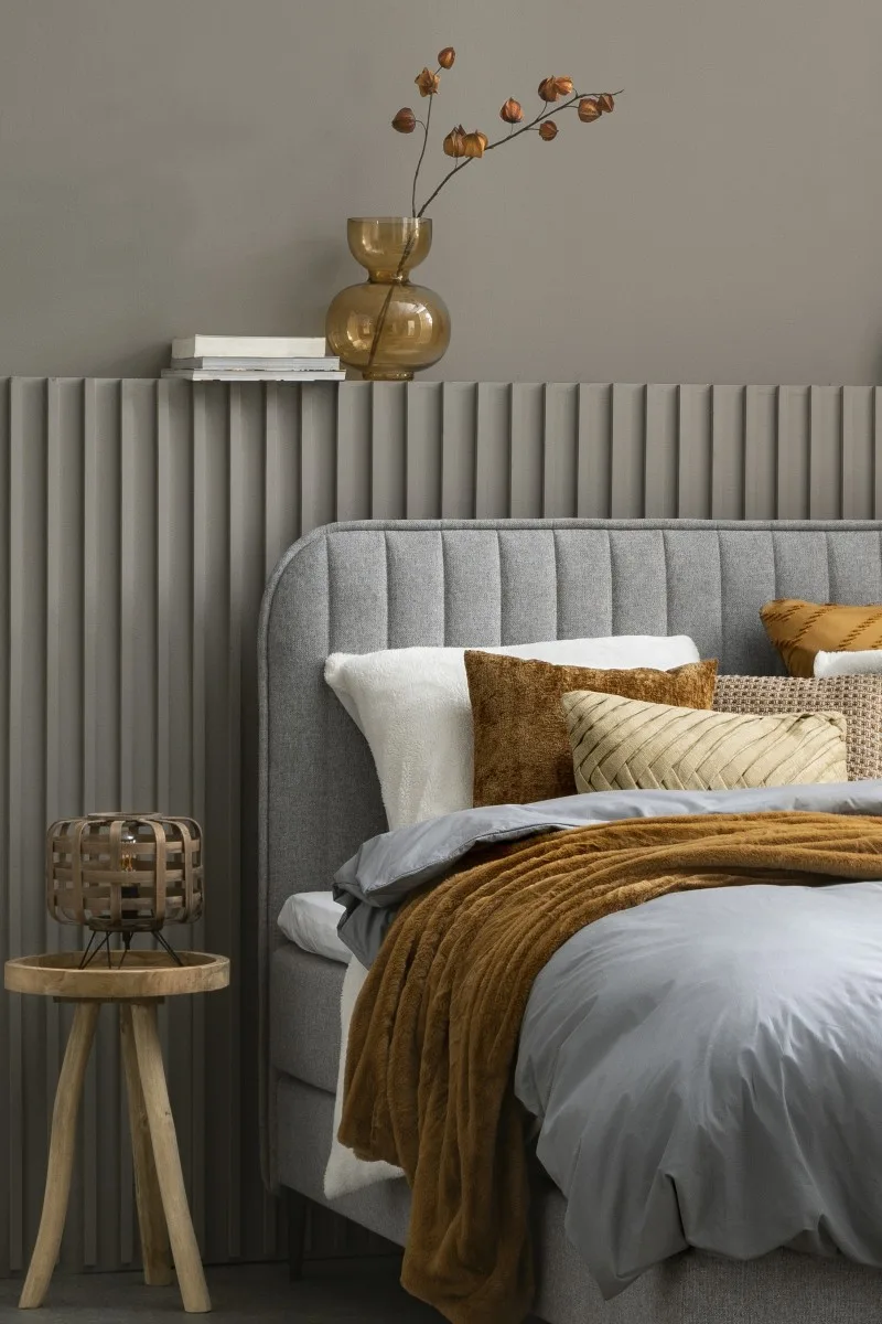 Caramel dekbedovertrek in slaapkamer met grijze boxspring