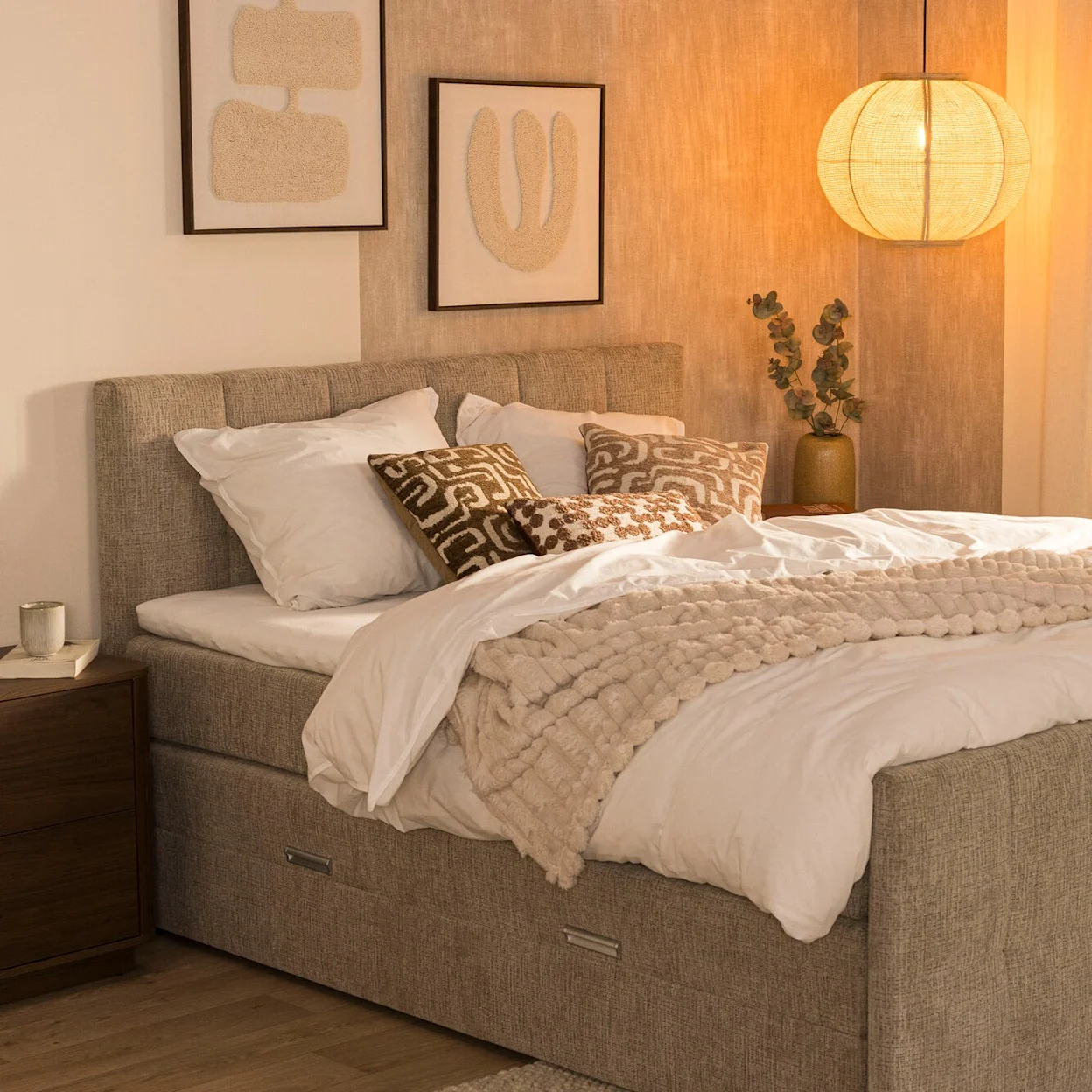 Taupekleurige boxspring Kanso met rustig hoofd- en voetbord in een lichte slaapkamer