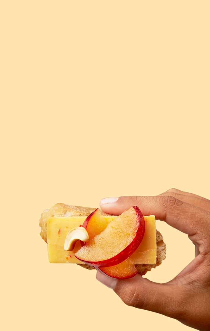 hand holding cheese and peach