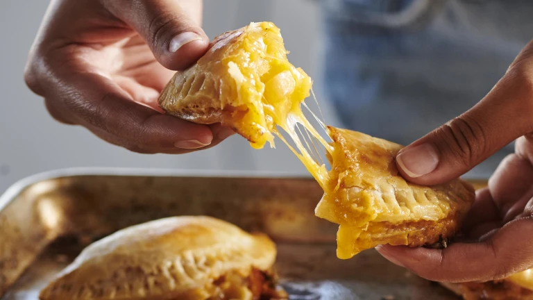 Person pulling apart Apple Cheddar Hand Pies made with Tillamook Cheddar