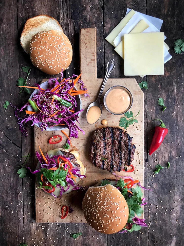 Cheeseburgers on board with condiments