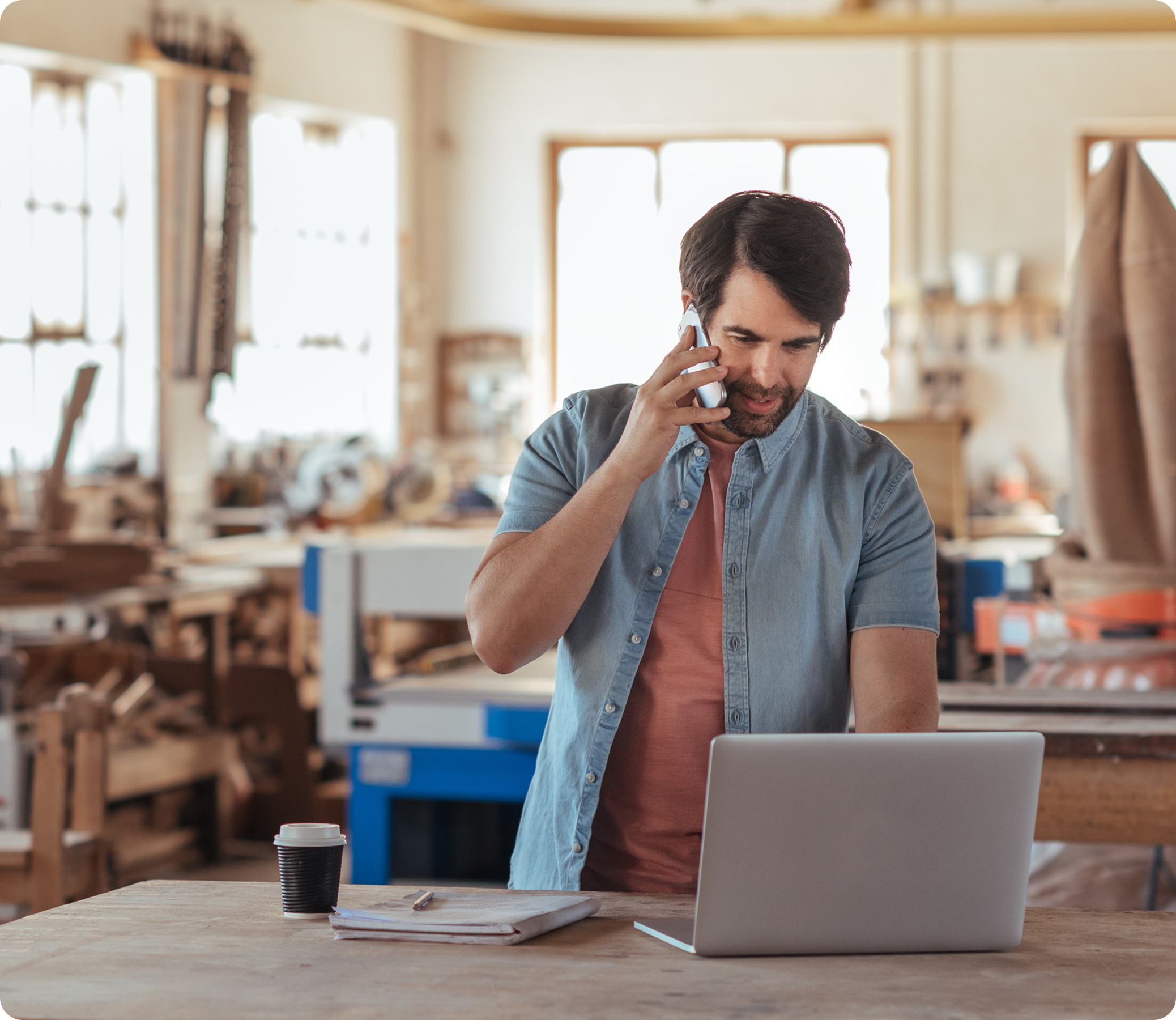 A man making a phone call while using laptop