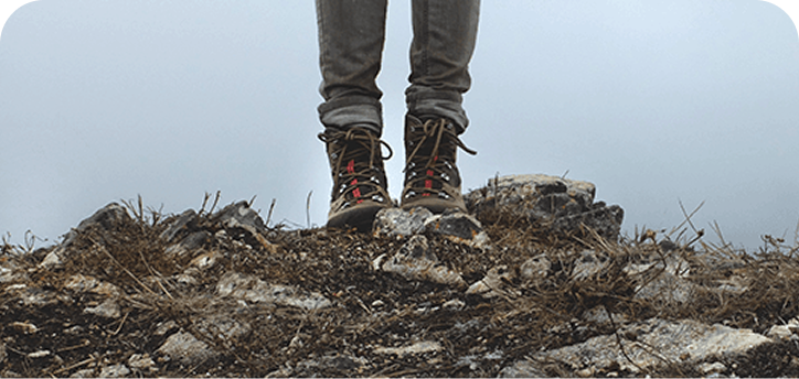 Man wearing boots on top of mountain