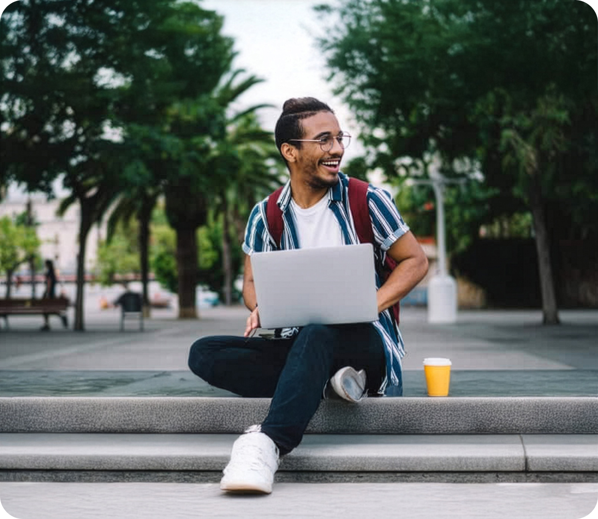 Man using computer on steps outside