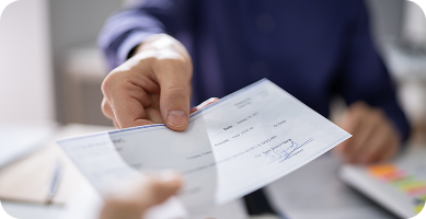 woman working on personal computer with a dslr camera next to her