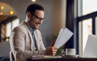 A smiling young professional looking at some documents