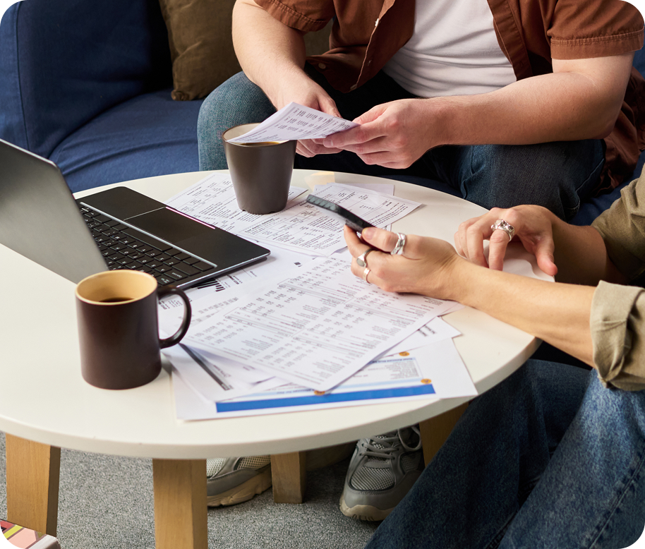 A lady smiling writing and working on laptop