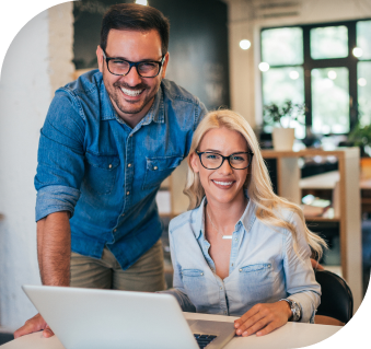 man and woman smiling toward the screen while working on paperwork