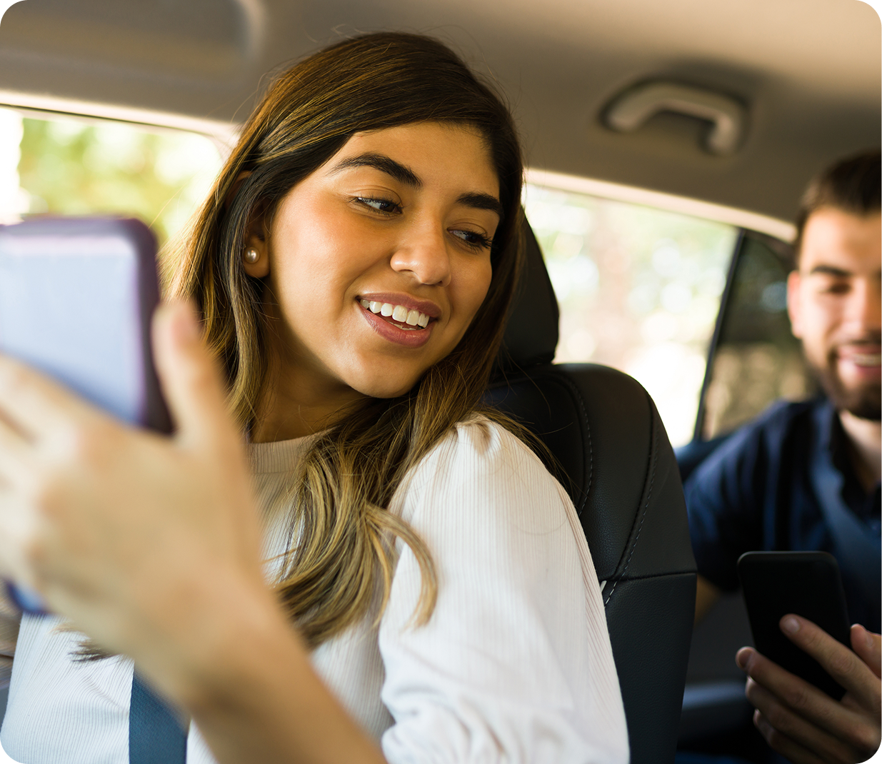 girl looking at the guy sitting behind her while holding phone