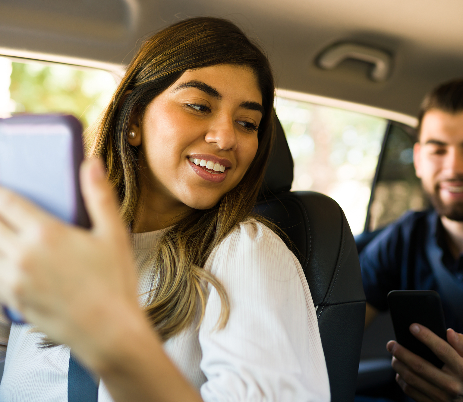 girl looking at the guy sitting behind her while holding phone