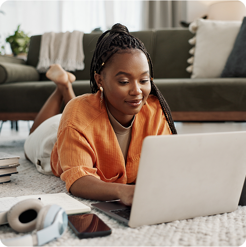 Woman working on her laptop resting on the floor