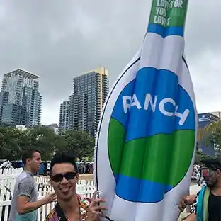 Person holding an inflatable float shaped like a Ranch bottle