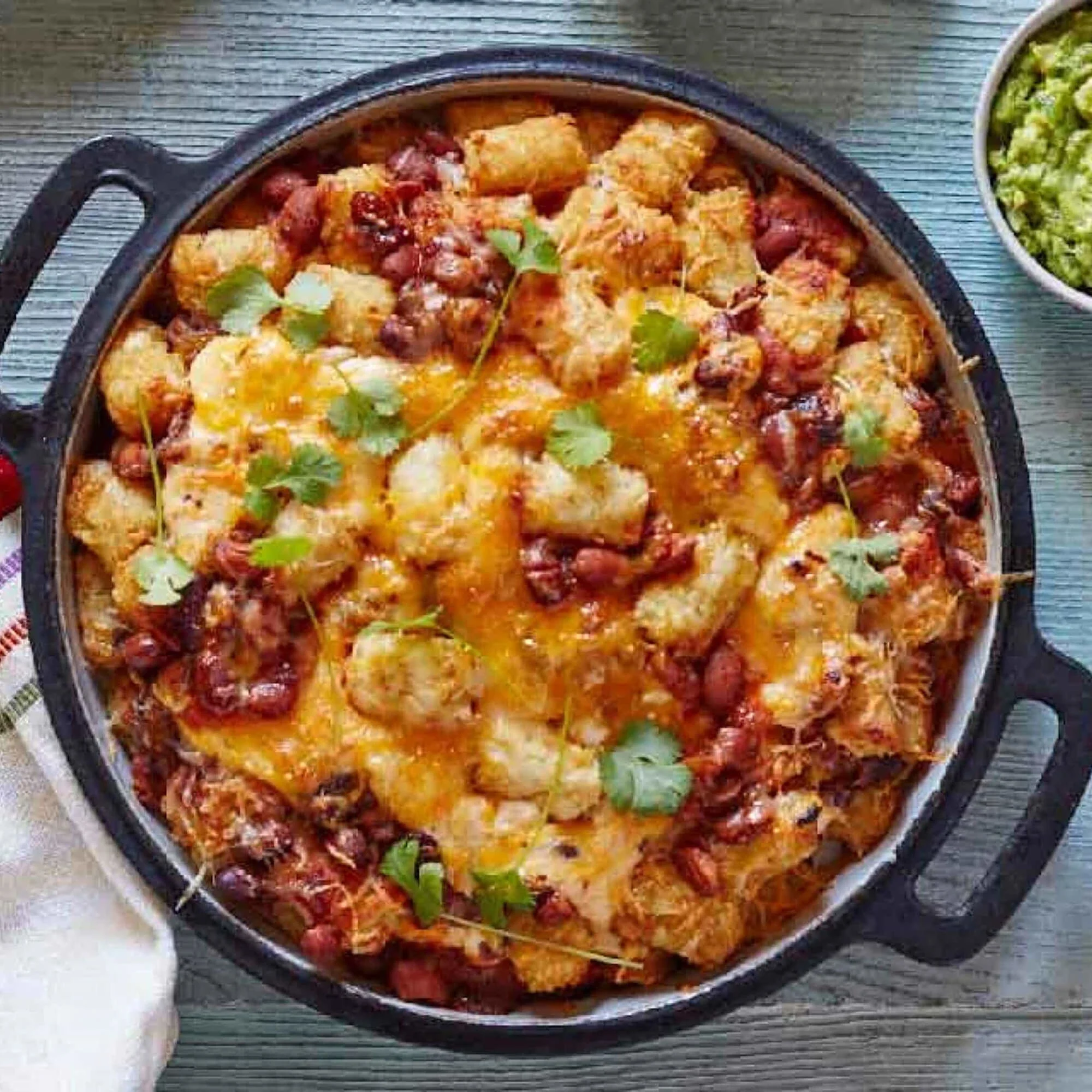 Overhead shot of baked tater tots and cheese in a skillet