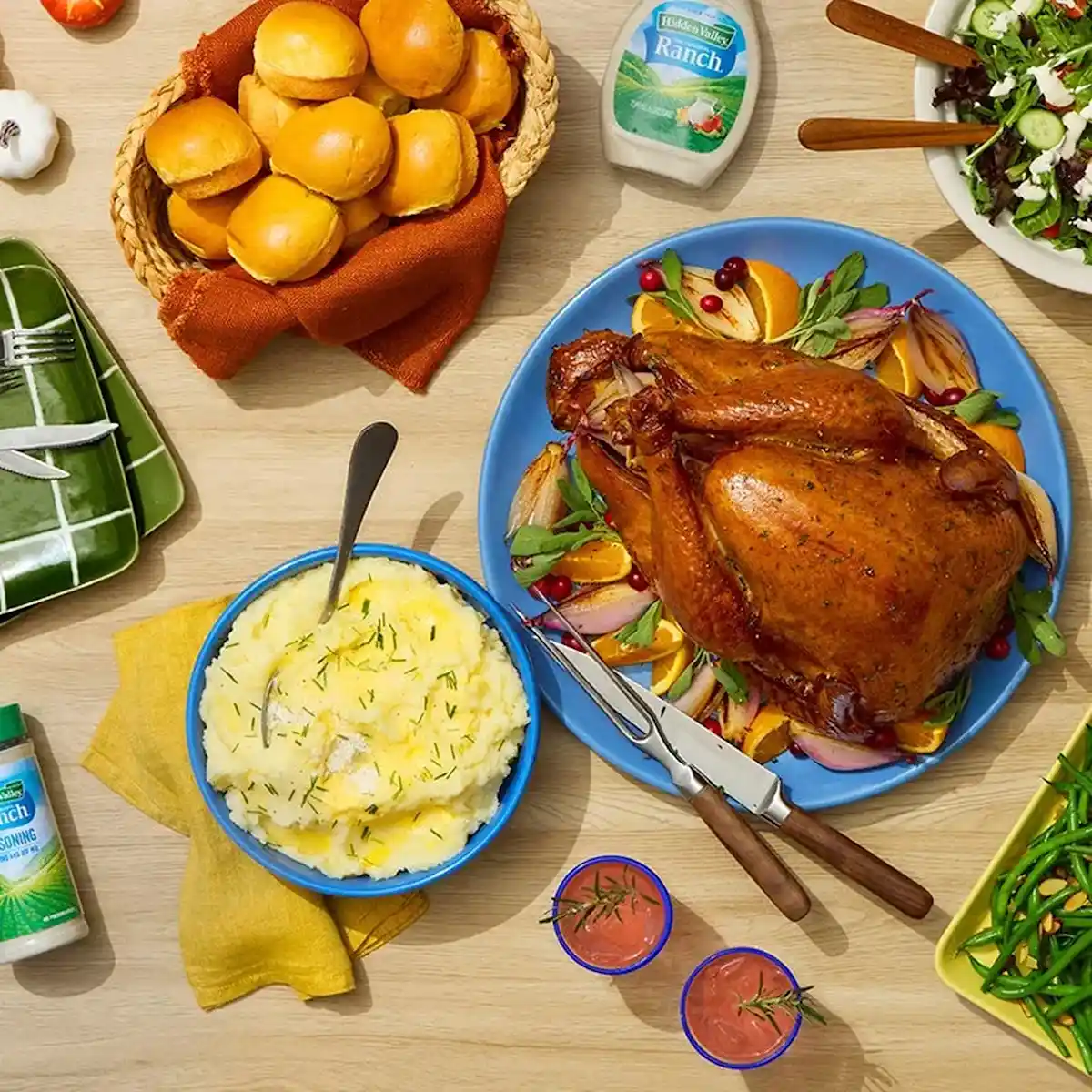 Overhead shot of turkey, mashed potatoes, bread rolls on a table