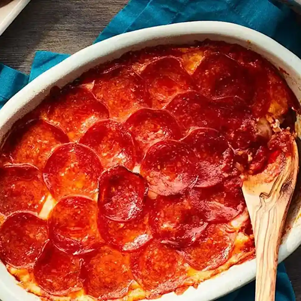 Pepperoni dip with a wooden spoon