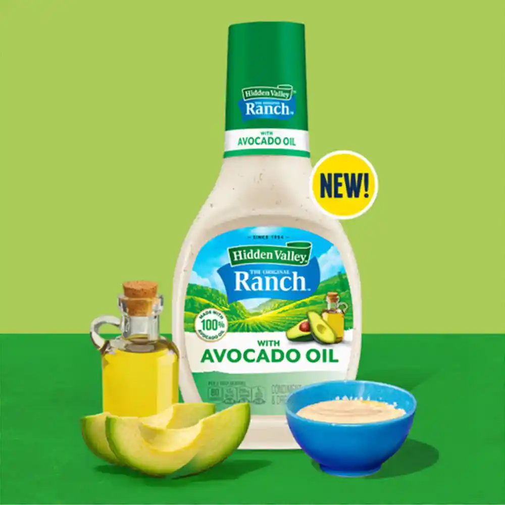 Avocado Oil Ranch dressing with a bottle of oil, avocado slices and a ramekin of dressing on a green background