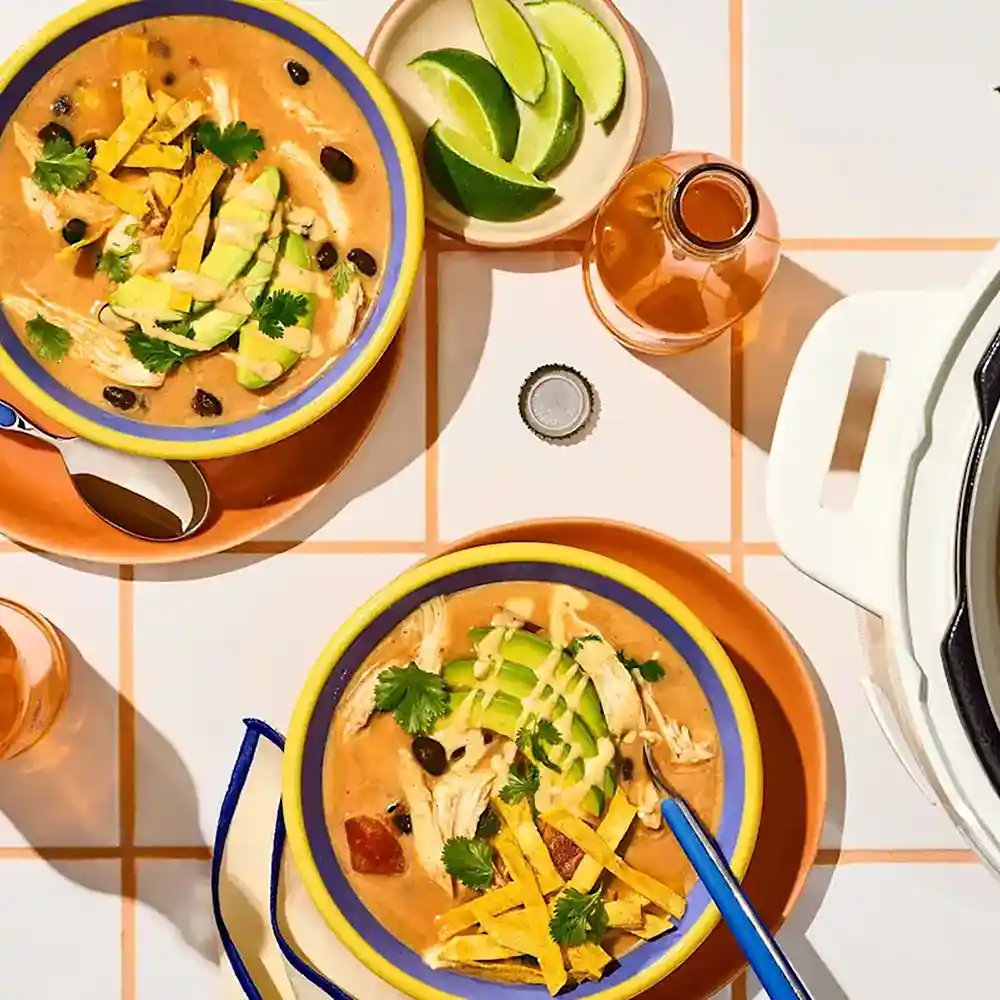 Tortilla soup with avocados on a checker patterned tablecloth