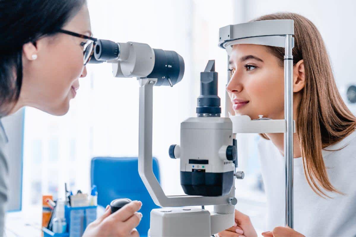 A young lady getting her eyes tested by an optometrist to check on her eye health
