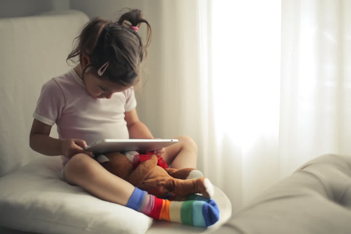 Parents POV of young girl on their tablet, wondering should parents limit screen time for their kid