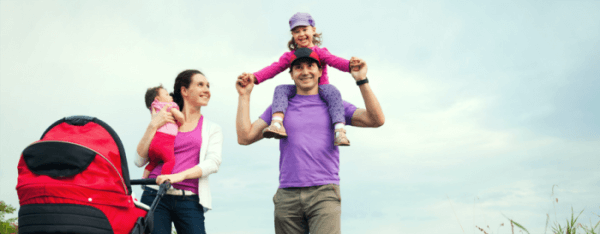 Young family smiling on an outdoor walk attempting to get fit and get healthy
