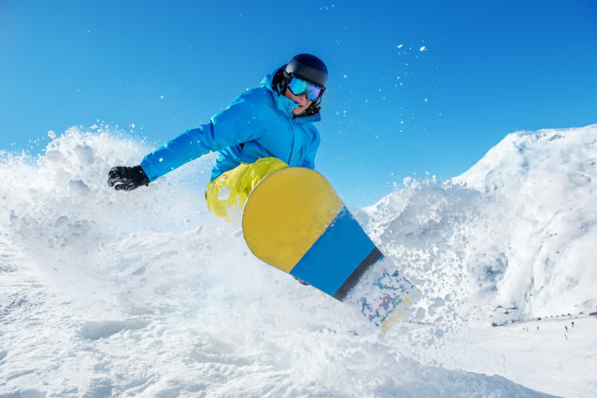 Young man snowboarding in thick snow, a great active holiday idea