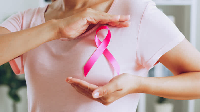 A female with a pink ribbon on her chest after going for a breast cancer check