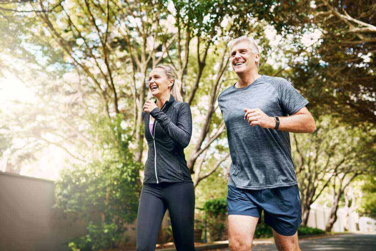 Older couple following a healthy ageing strategy by running together and staying active