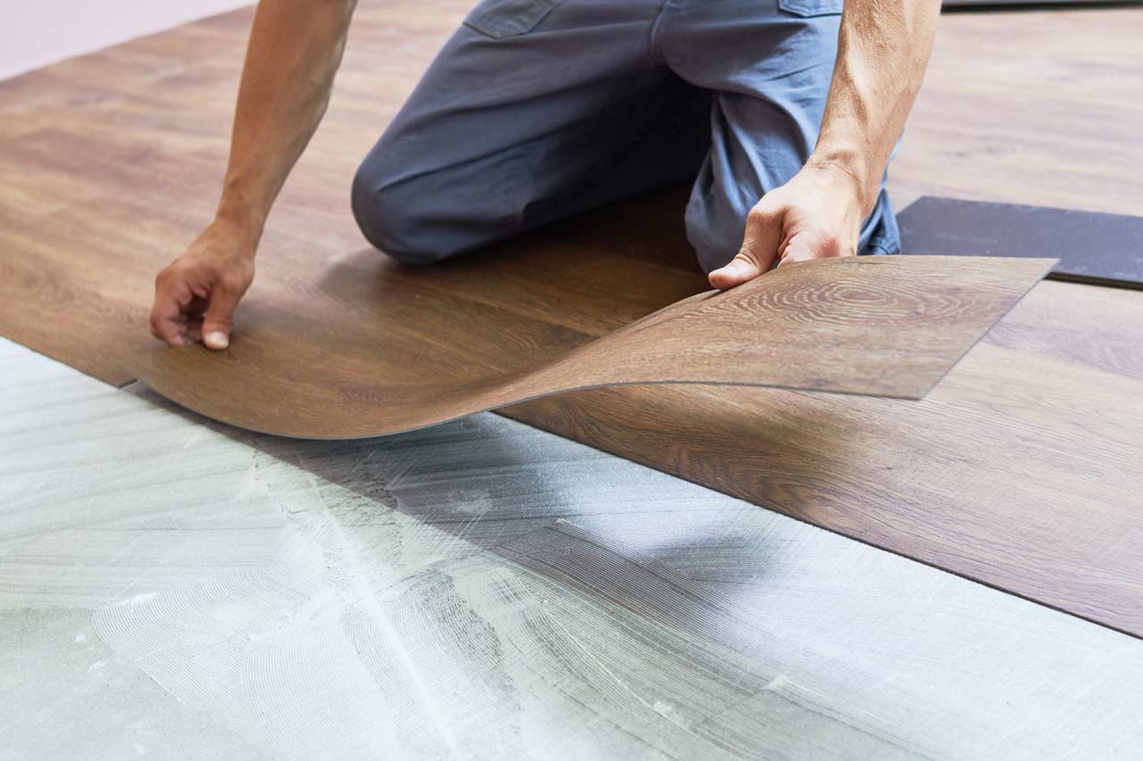 A worker placing new EVP flooring
