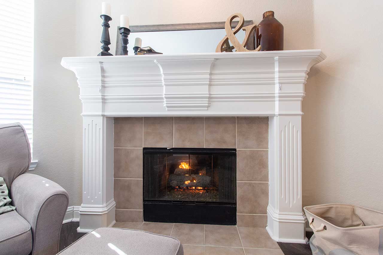 Fireplace with tiled surround and white mantel
